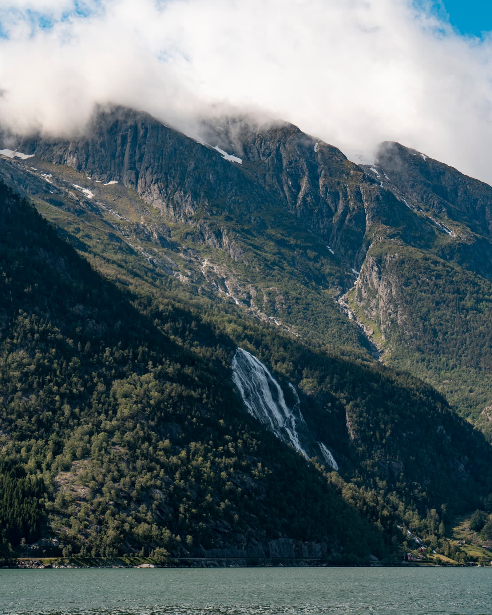 A waterfall descending from the mountains to the fjord in Western Norway
